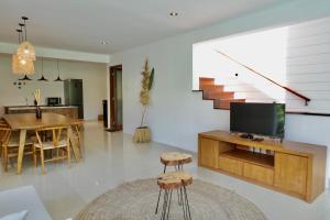 ein Wohnzimmer mit einem TV und einem Tisch mit einem Esszimmer in der Unterkunft Casa Naima Petitenget Villa in Seminyak