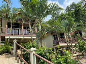 a house with palm trees in front of it at Redang De' Rimba in Redang Island