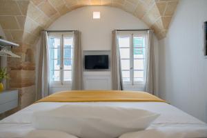 a bedroom with a bed and two windows at Samarés in Ciutadella