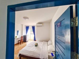 um quarto com uma cama com um cão sentado nela em Blue House em Ang Thong