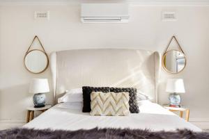 um quarto com uma grande cama branca e 2 espelhos em 94 Highett - 5 bedroom, 3 car parks - Luxury House em Melbourne