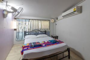 a bed in a room with a window and a bed sidx sidx sidx at 7 Holder Guesthouse in Bangkok