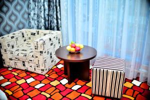 a room with a table and a chair with a bowl of fruit at Sapar Standart Hotel in Shymkent