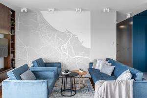 a living room with two blue couches and a table at Sea view apartment in Gdańsk