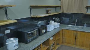 a kitchen counter with a microwave and a sink at RQ Cozy Two Bedroom House in General Santos