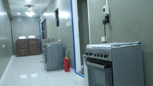 a kitchen with a stove and a fire extinguisher at RQ Cozy Two Bedroom House in General Santos