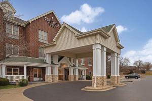 a hotel with a large building with a sign on it at Country Inn & Suites by Radisson, Schaumburg, IL in Schaumburg