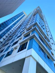 a tall blue building looking up into the sky at One Pacific Place Serviced Residences in Manila