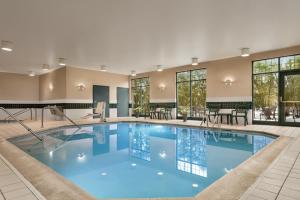 a large pool in a hotel with tables and chairs at Country Inn & Suites by Radisson, Schaumburg, IL in Schaumburg