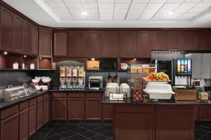 a kitchen with brown cabinets and a counter with fruit on it at Country Inn & Suites by Radisson, Schaumburg, IL in Schaumburg