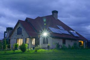 a house with solar panels on the roof at Bessotted Farmstay in Nanyuki