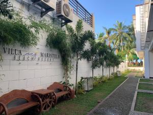 a building with a sign on the side of it at Villa MJ Maristela Beach Resort in Lemery