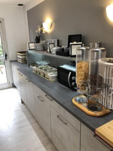 a kitchen with a counter with a counter top with food at Hôtel Restaurant le Privilège - authentic by balladins in Verdun-sur-Meuse