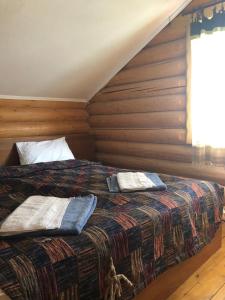 Schlafzimmer mit einem großen Bett und Holzwänden in der Unterkunft Золото Карпат in Izky