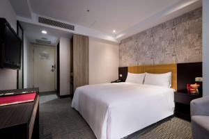 a hotel room with a large bed and a flat screen tv at 台北碧瑤飯店 Hotel B in Taipei