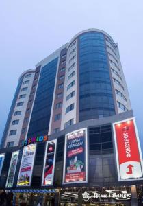 un edificio alto con señales delante en Люкс апартаменты .РАЙОН АВТОВОКЗАЛА,в ЖК Арена, en Rivne