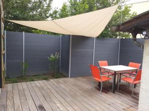 un patio con mesa y sillas en una terraza en Joli 2 pièces esprit loft moderne en Pau