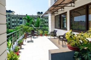 a balcony with chairs and plants on a building at Yaksha Holiday Home in Siliguri