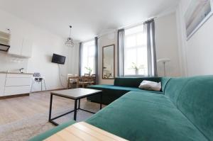 瓦多維採的住宿－Apartament Mickiewicza，客厅配有绿色沙发和桌子