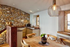 een keuken en eetkamer met een tafel en een stenen muur bij Aldilà Art Rooms, Apartment and Vacation House in Šmartno