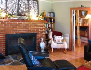 a living room with a brick fireplace and a chair at Fivespot Cabin in Pinehurst