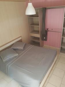 1 dormitorio con 1 cama grande y pared de color rosa en gite des jardiniers en Fumay