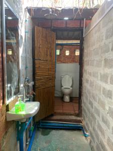 a bathroom with a toilet and a sink at Bamboo Forest River View Hostel in Ywama