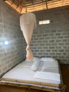 uma cama com uma rede mosquiteira em cima em Bamboo Forest River View Hostel em Ywama