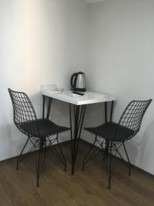 a table with two chairs and a tea kettle on it at Kule Hotel in Bursa