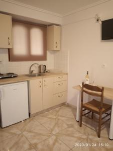 a kitchen with a table and a chair in it at Bellarias House in Nydri