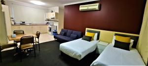 a small room with two beds and a kitchen at Brunswick Tower Hotel in Melbourne