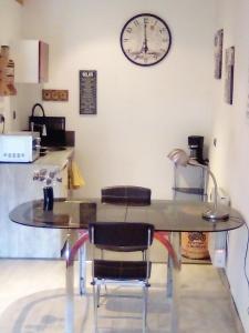 a table with chairs and a clock on the wall at Dolce Casa in Sainte-Foy-lès-Lyon