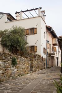 Une allée avec un mur en pierre et un bâtiment dans l'établissement Aldilà Art Rooms, Apartment and Vacation House, à Šmartno