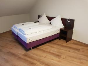 een bed in een kamer met een houten vloer bij ates Hotel Lampertheim in Lampertheim