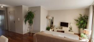 sala de estar con sofá y plantas en las paredes en Jardim na Praia, en Matosinhos