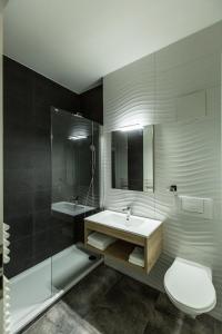 a bathroom with a toilet, sink, and bathtub at Campanile Martigny in Martigny-Ville