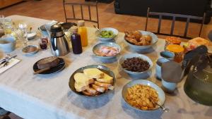 una mesa con muchos tazones de comida. en Le Nichoir, en Les Essarts