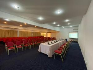 una sala de conferencias con mesas, sillas y una pantalla en Alazani Valley Hotel en Telavi