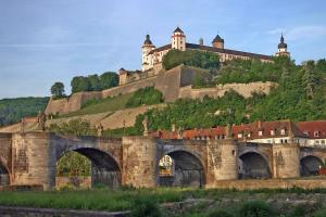 a castle on top of a hill with a bridge at Luxury city apartment - view of river and castle in Würzburg