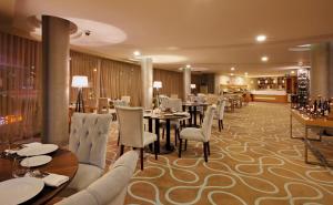 a restaurant with tables and chairs and a bar at Anemon Grand Adana Otel in Adana