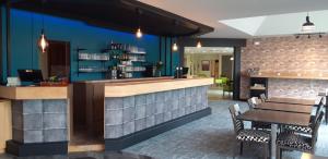 a bar in a restaurant with a table and chairs at Hôtel Cositel, Coutances in Coutances