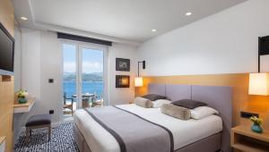 a bedroom with a bed and a view of the ocean at Royal Neptun Hotel in Dubrovnik