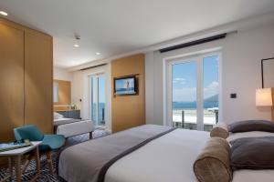 a hotel room with a large bed and a window at Royal Neptun Hotel in Dubrovnik