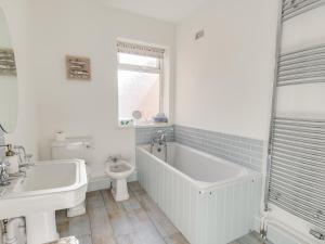 a bathroom with a tub and a toilet and a sink at Seahorse Cottage in Weymouth +13 photos
