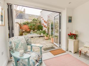 a living room with a chair and a patio at Seahorse Cottage in Weymouth