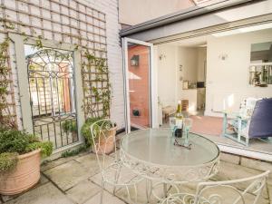 a glass table and chairs on a patio at Seahorse Cottage in Weymouth