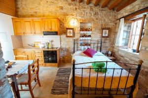a bedroom with a bed and a table in a room at Constantias stone houses in Lofou +11 photos