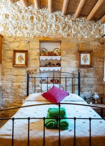 a bedroom with a bed in a stone wall at Constantias stone houses in Lofou