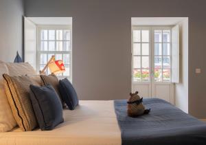 a bed with a stuffed animal sitting on top of it at Matriz Lofts in Ponta Delgada +41 photos