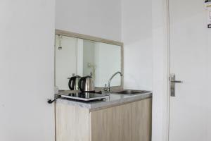 a kitchen with a sink and a mirror at Minimalist Studio Apartment at Poris 88 with City View By Travelio in Tangerang